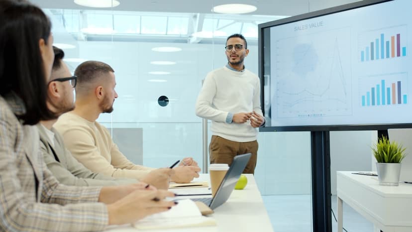 Man presenting charts to colleagues in a meeting. - Photo by Vitaly Gariev on Unsplash