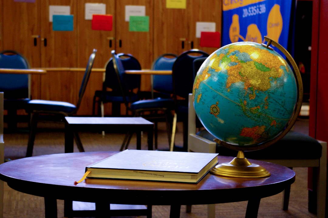 a globe sits on a table in a classroom - Photo by Matthew Kirk on Unsplash